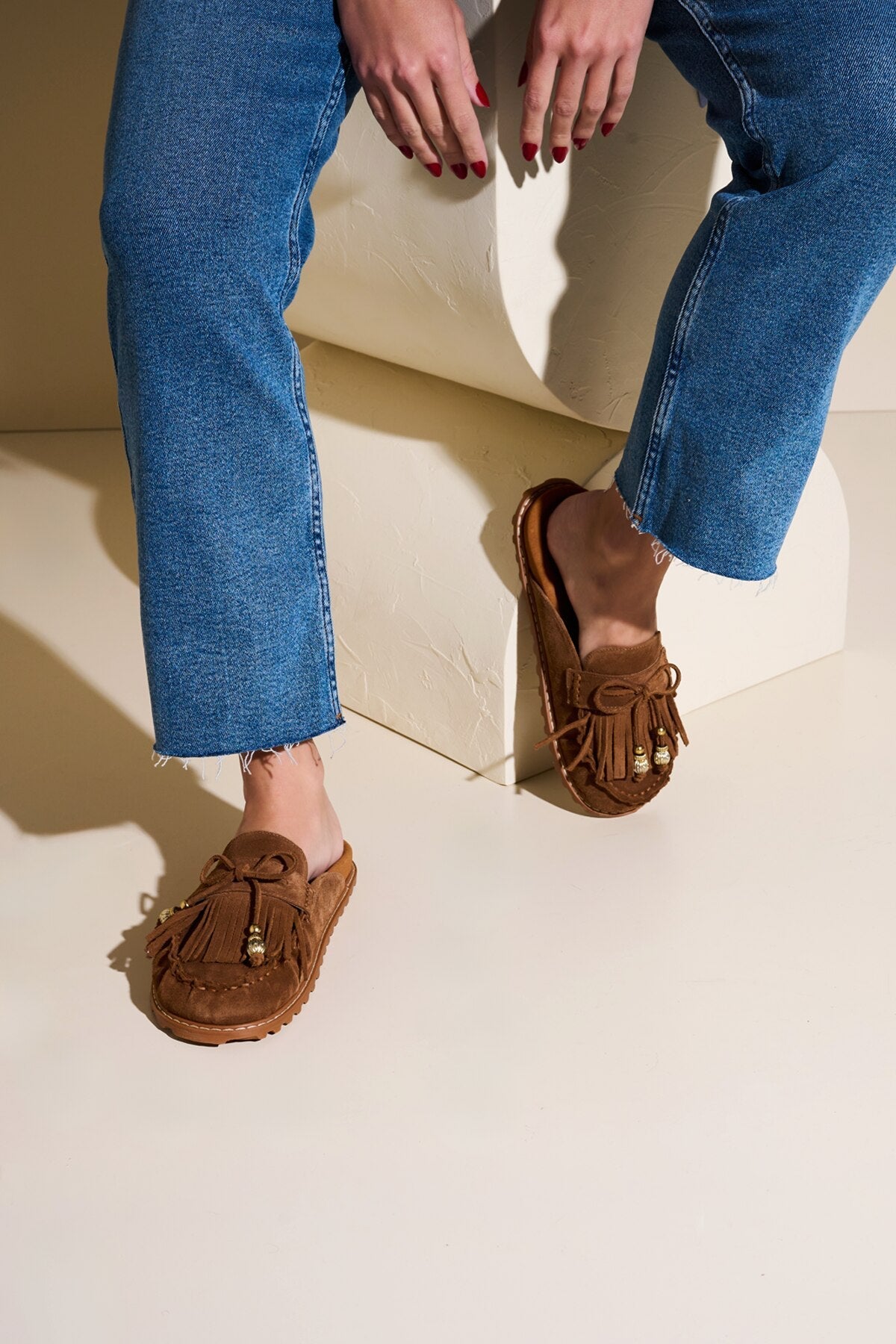 MULE MOCASSIM EM CAMURÇA CARAMELO COM FRANJAS E METAL DOURADO